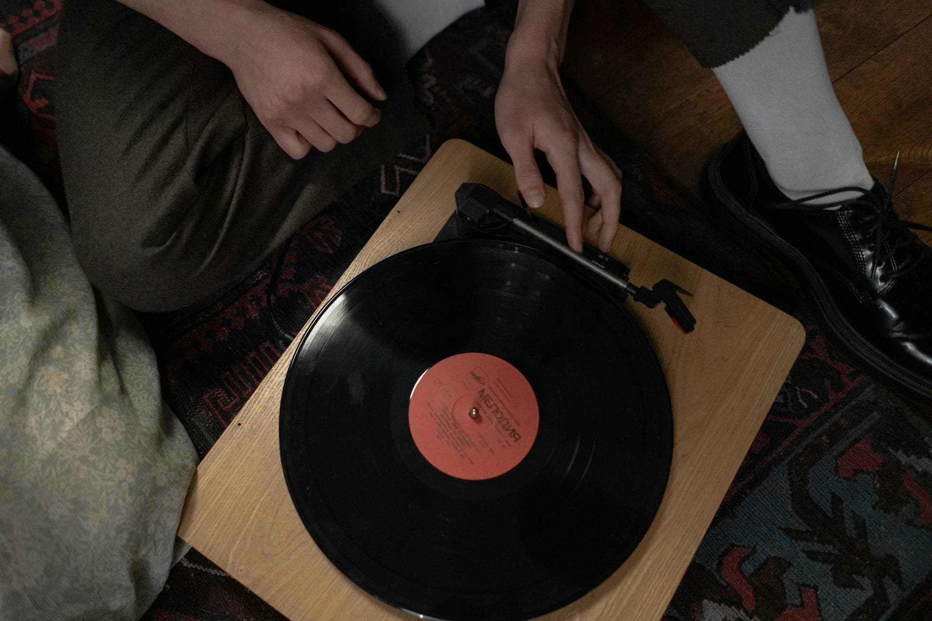 Hands placing a record on a turntable